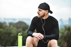 Wrist Prints: Muscular bearded athlete checking burned calories on smart watch after good workout session on city