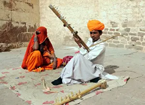 Stringed Prints: A musician in an orange turban plays a stringed instrument in a courtyard of the Meherangarh