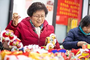 Shoe Prints: NANTONG, CHINA - JANUARY 18, 2022 - A group of skilled women sew tiger-head shoes for the upcoming Spring Festival