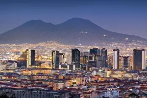 Naples, Italy with the financial district skyline under Mt. Vesuvius at twilight