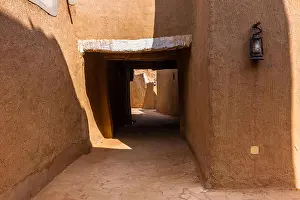 Occupied Prints: A narrow covered passage in the traditional Arab mud brick village in Al Majmaah