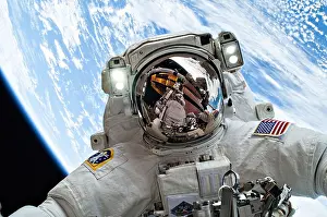 NASA astronaut Mike Hopkins takes a selfie with the Earth as background as he takes part in a spacewalks to change out a faulty water pump