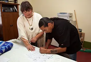 First Nations Prints: Native American man signs paperwork and documents in an office