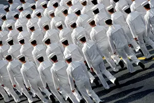 Conformity Prints: US navy parade shot from above and behind showing many men in white uniform from the back