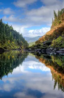 Trunk Prints: Nearly perfect fall reflections with blue sky and fluffy white clouds while rafting down the Rogue River in Oregon