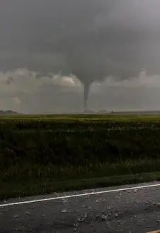 Threat Prints: A nearly rain-wrapped tornado touches down near a farm in Kansas