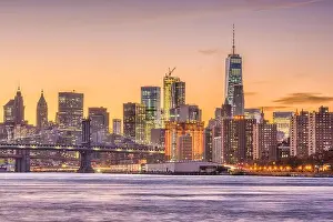 New York City, USA skyline on the East River with Brooklyn Bridge at dusk