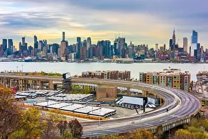 New York, New York, USA cityscape and highways from across the Hudson River at dusk