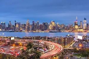 New York, New York, USA cityscape and highways from across the Hudson River at dusk