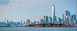 New York, New York, USA skyline from the harbor with Ellis Island at dusk