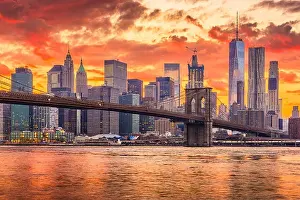 New York, New York, USA skyline of Manhattan on the East River with Brooklyn Bridge after sunset