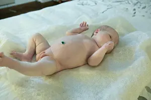 Newborn baby girl lies on the bed. The baby has just turned two weeks old. Newborn care concept