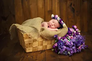 New Life Prints: Newborn baby girl with a wreath in a wicker basket with a bouquet of purple wild flowers