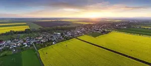 Canola Prints: Nice aerial sunset landscape over yellow - green fields with rural village