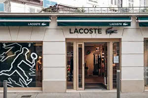 French Riviera Prints: Nice, France - February 28, 2026: Exterior views and window displays of a Lacoste boutique in central Nice