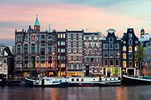 Night Amsterdam city view of Netherlands traditional houses with Amstel river in Amsterdam, Netherlands