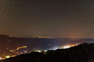 Milky Way Prints: Night intermountain city of Smolyan with bright evening electric lights under a clear sky with bright small stars