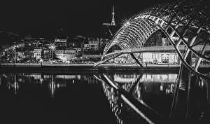 Caucasus Prints: Side night view of illiuminated the bridge of peace and old town in the background