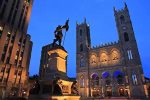 Cnmages Prints: The night view of Place d'Armes with Notre-Dame Basilica and Maisonneuve Monument in foreground in Old Montreal