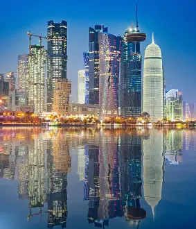 Corniche Prints: Night view of skyline along waterfront of Corniche towards modern office towers in West Bay district in Doha Qatar