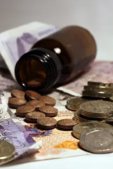 Tablets Prints: Non descript pills out of brown bottle on back ground of coins & money