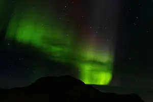 Northern Lights Prints: Northern lights above a montaga in the city of Vik, Iceland
