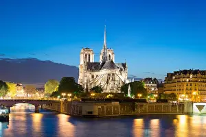 Notre Dame de Paris with cruise ship on Seine river at night in Paris, France