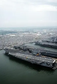 The nuclear-powered aircraft carrier USS THEODORE ROOSEVELT (CVN-71), foreground, lies tied up beside the nuclear-powered aircraft carrier USS DWIGHT