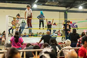 Oaxaca Prints: Oaxaca de Juárez, Oaxaca, Mexico - Children play in the ring before a Lucha Libre wrestling match