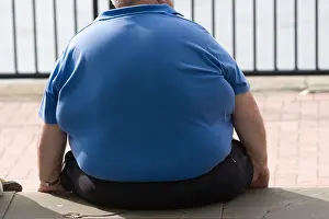 Obese Prints: Obese man sitting on wall, Cardiif, Wales, UK