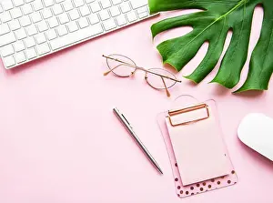 Office desk working space - Flat lay top view of working space with keyboard and notebook on pink pastel background
