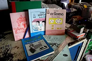The official Lao government primary school textbooks and workbooks rest on a table at a store in Luang Prabang, Laos