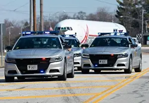 Ohio State Highway Patrol officers escort the fuselage of a Boeing 767 as it moves along Kauffman Avenue in Fairborn