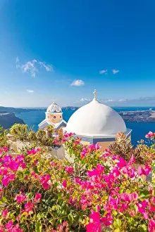 Oia town on Santorini island, Greece. Traditional famous white blue houses with flowers under sunny weather caldera, Aegean sea. Beautiful summer view