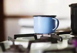 Campsite Prints: Old blue metal mug on gass cooker