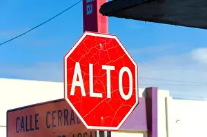Halt Prints: An old, cracked, grungy road sign saying ‘Alto which means Stop in Spanish