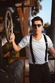 Concentrated Prints: Old-fashioned hipster guy in a shirt with suspenders turns the old valve