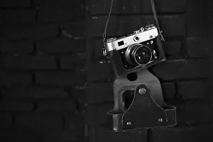 Reel Prints: Old film camera on black wall. Image for design