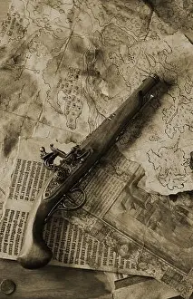 Thrill Prints: old flintlock pistol on old pirate maps and manuscript pages