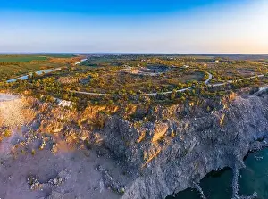 Old River Prints: Old flooded stone quarry with large stones in the evening warm bright light covered with small dry plants