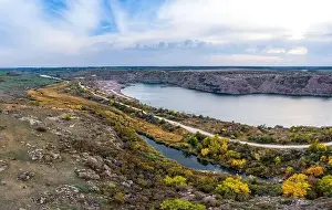 Fall Lake Prints: Old flooded stone quarry with large stones in the evening warm bright light covered with small dry plants
