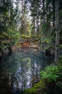 Old and historical mine full with greenish jade color water in middle of forest. This mine is over 500 hundred years old