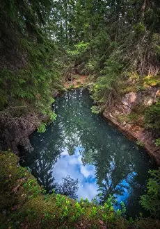 Old and historical mine full with greenish jade color water in middle of forest. This mine is over 500 hundred years old