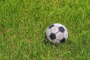 Soccer Ball Prints: Old leather soccer ball on green grass with copy space, football sport concept