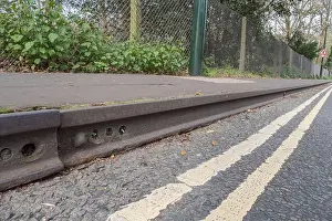 Rails Prints: Old railway tracks (rails) used as road kerbs on Queens Ride, Barnes, London, UK