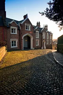 Terraced Prints: The old rectory at St Marys Hill in Chester as the sun begins to light the cobbled road in front of the building