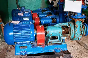 Coil Prints: Old, rusty scratches water pump with an electric motor dyed in blue color on the cold water pipe