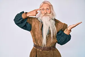 Displeased Prints: Old senior man with grey hair and long beard wearing viking traditional costume confused