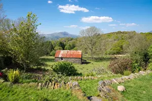 Fine Weather Prints: Old stone barn in the hills of Snowdonia with views of the mountains beyond