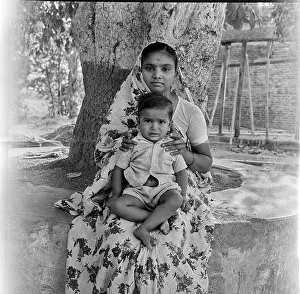 Insides Prints: old vintage 1900s black and white picture of Indian mother son portrait under tree India 1940s